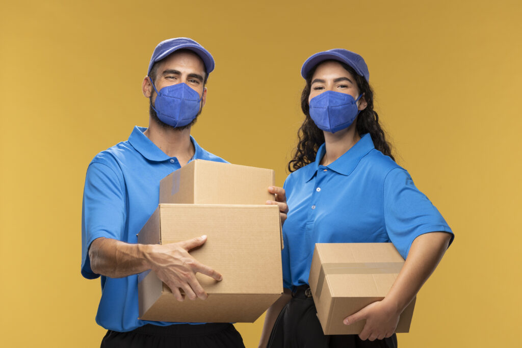 portrait male female deliverers with medical masks holding cardboard boxes